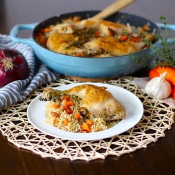 Baked Chicken and rice on a plate with the skillet dish in the background.
