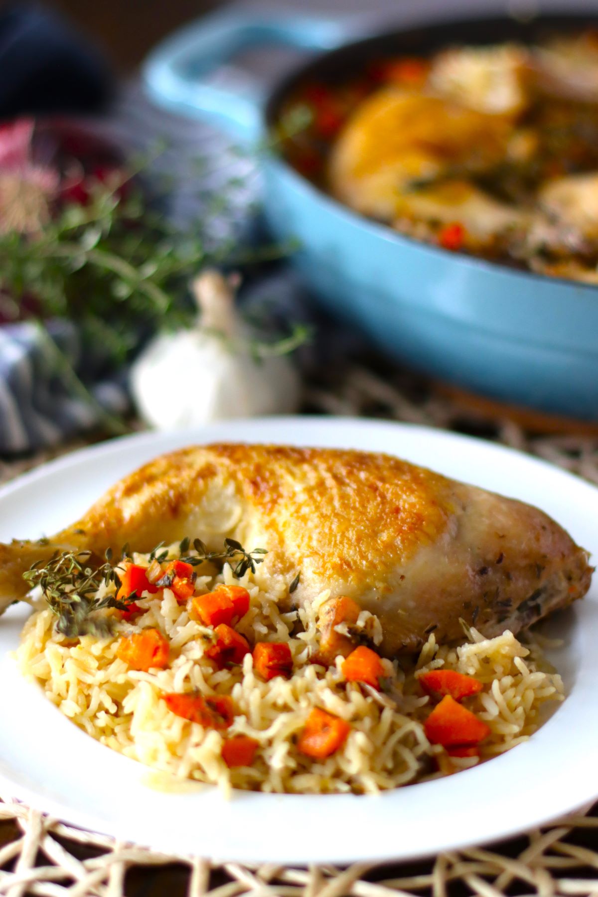 A baked quarter chicken on a plate with rice and vegetables. 