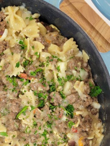 A pasta and meat dish inside of a cast iron skillet.
