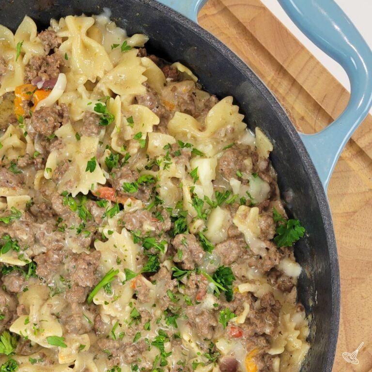 A pasta and meat dish inside of a cast iron skillet.