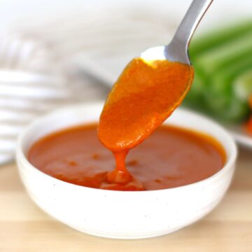 Mild Buffalo Sauce being spooned from a container.