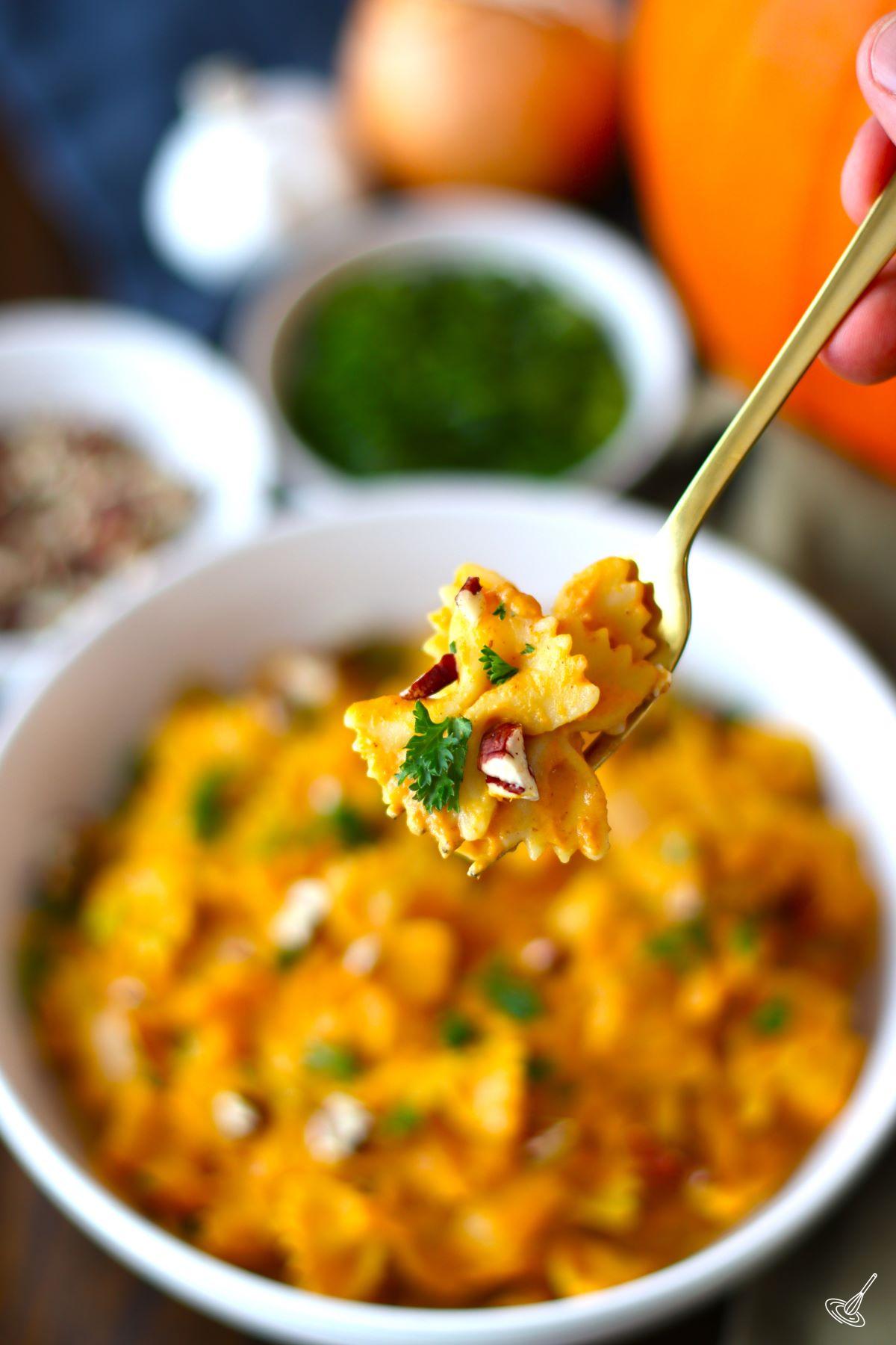 Pumpkin Pasta Sauce Recipe on a fork with the dish in the background.