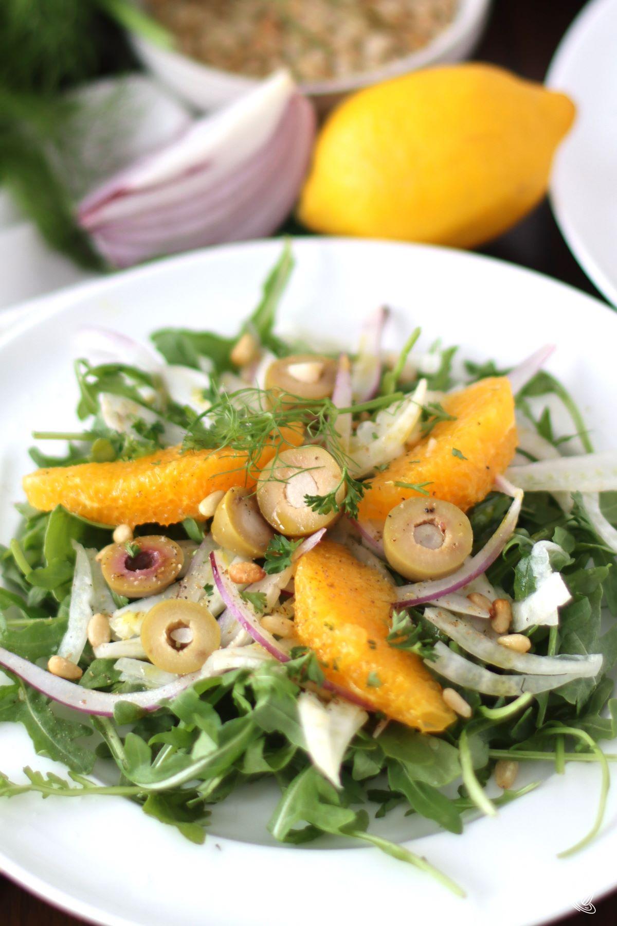 Arugula and fennel salad on a white plate.
