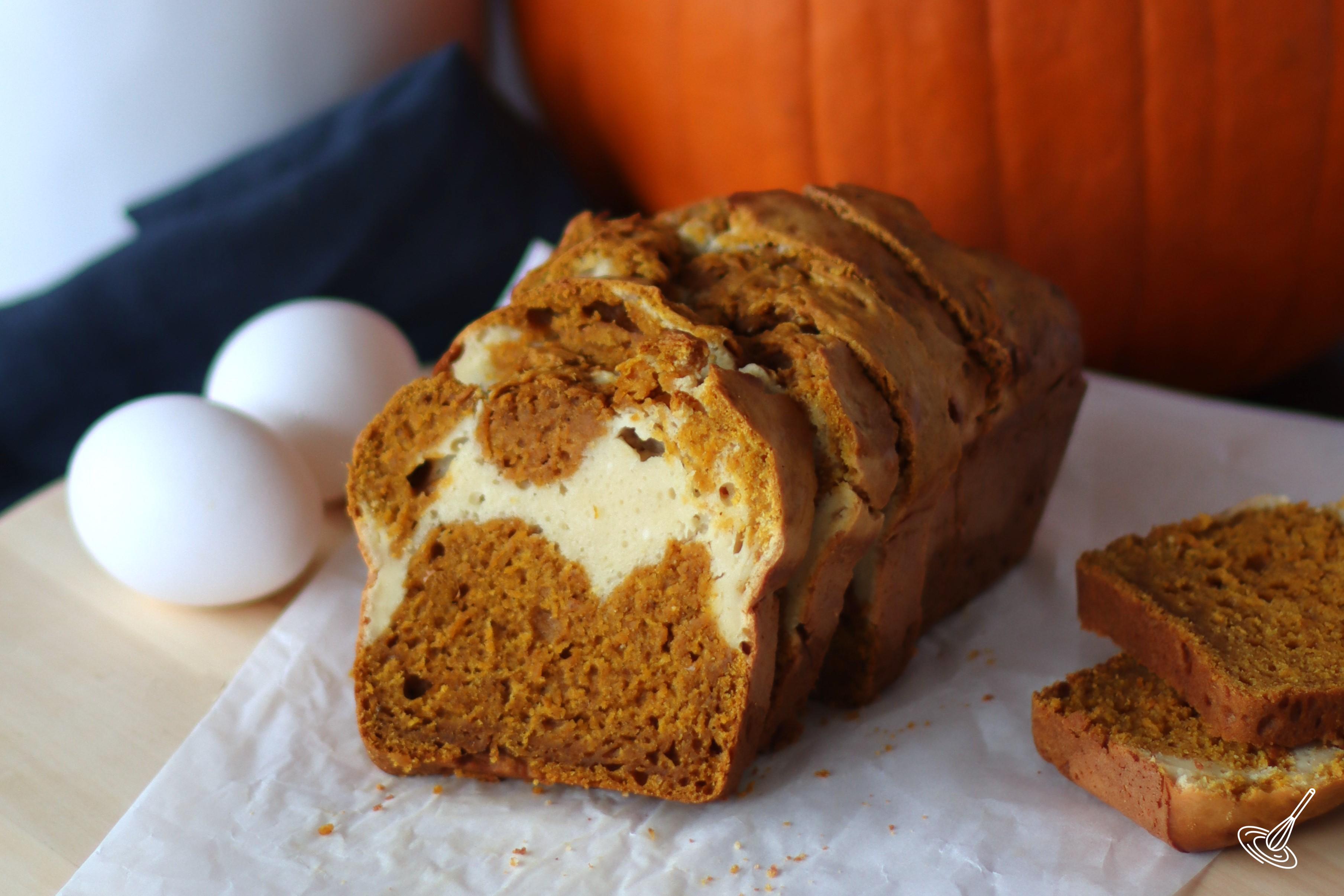 A sliced pumpkin swirl bread on a piece of parchment paper.