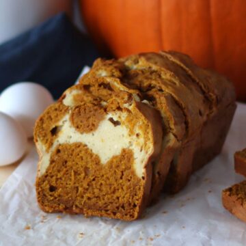 A sliced pumpkin swirl bread on a piece of parchment paper.