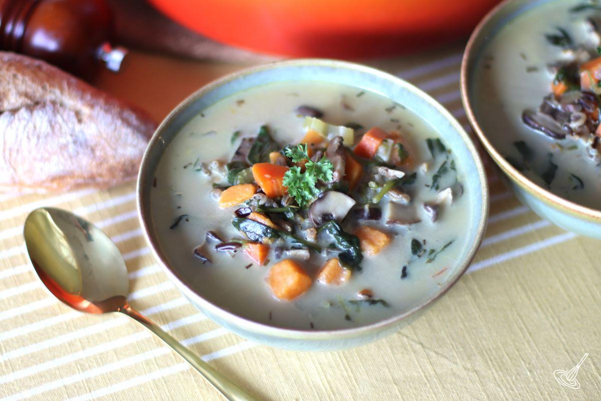 A bowl of Cozy Autumn Wild Rice Soup on a table.