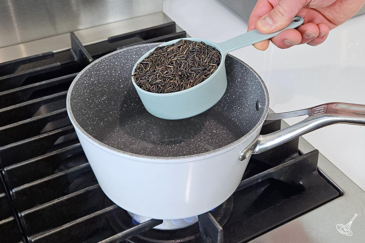 Someone cooking wild rice in a pot. 
