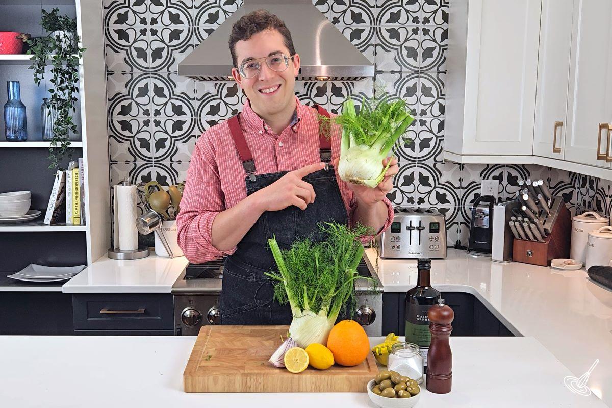 A man holding up a bulb of fennel.