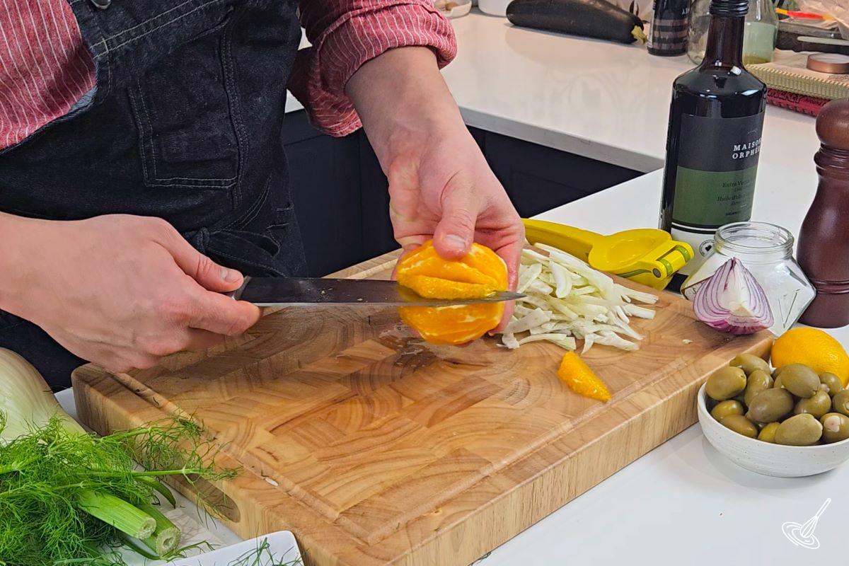 Someone segmenting a large orange.