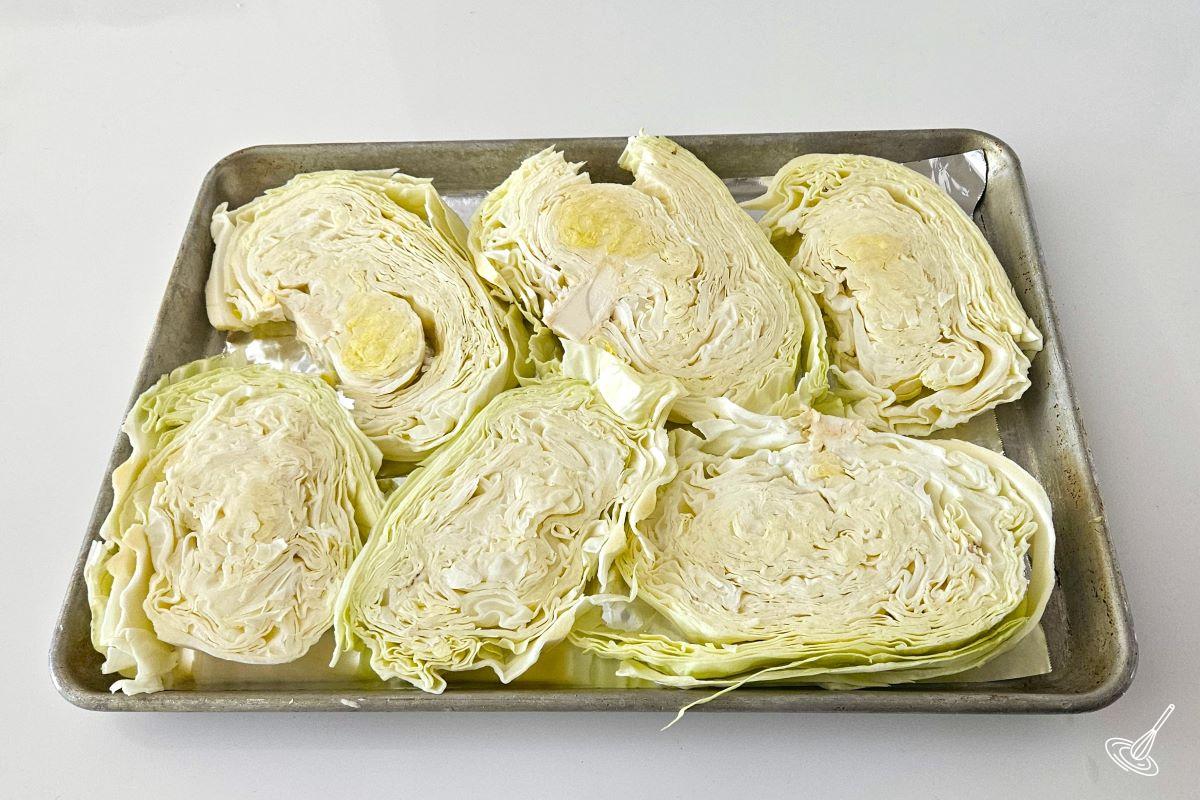 Slices of cabbage on a baking sheet.