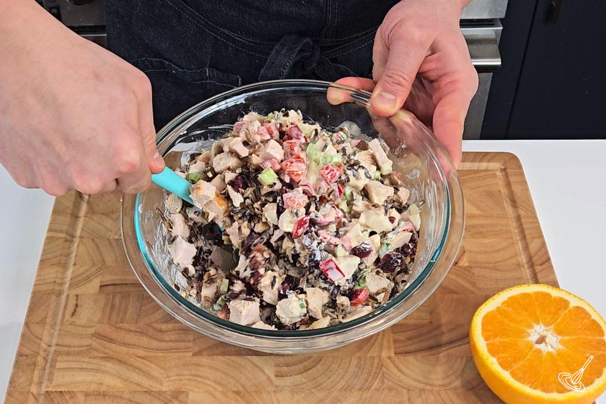 Chicken Wild Rice Salad being mixed together in a large bowl. 
