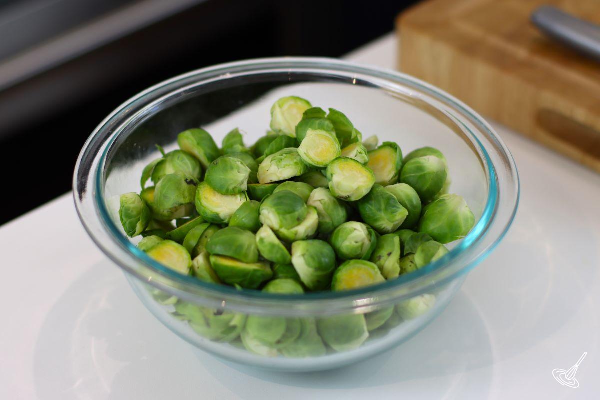 A large bowl of cleaned, and halved, brussels sprouts.