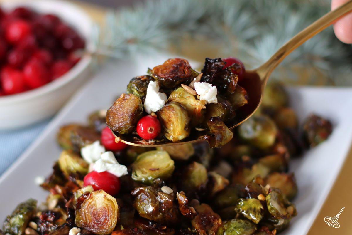 Someone holding up a spoon containing Hot Honey Brussel Sprouts.