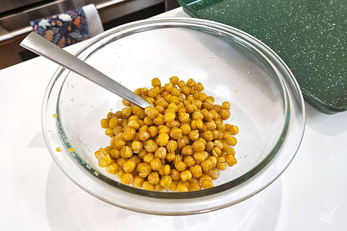 Toasted chickpeas in a small bowl with honey and olive oil.
