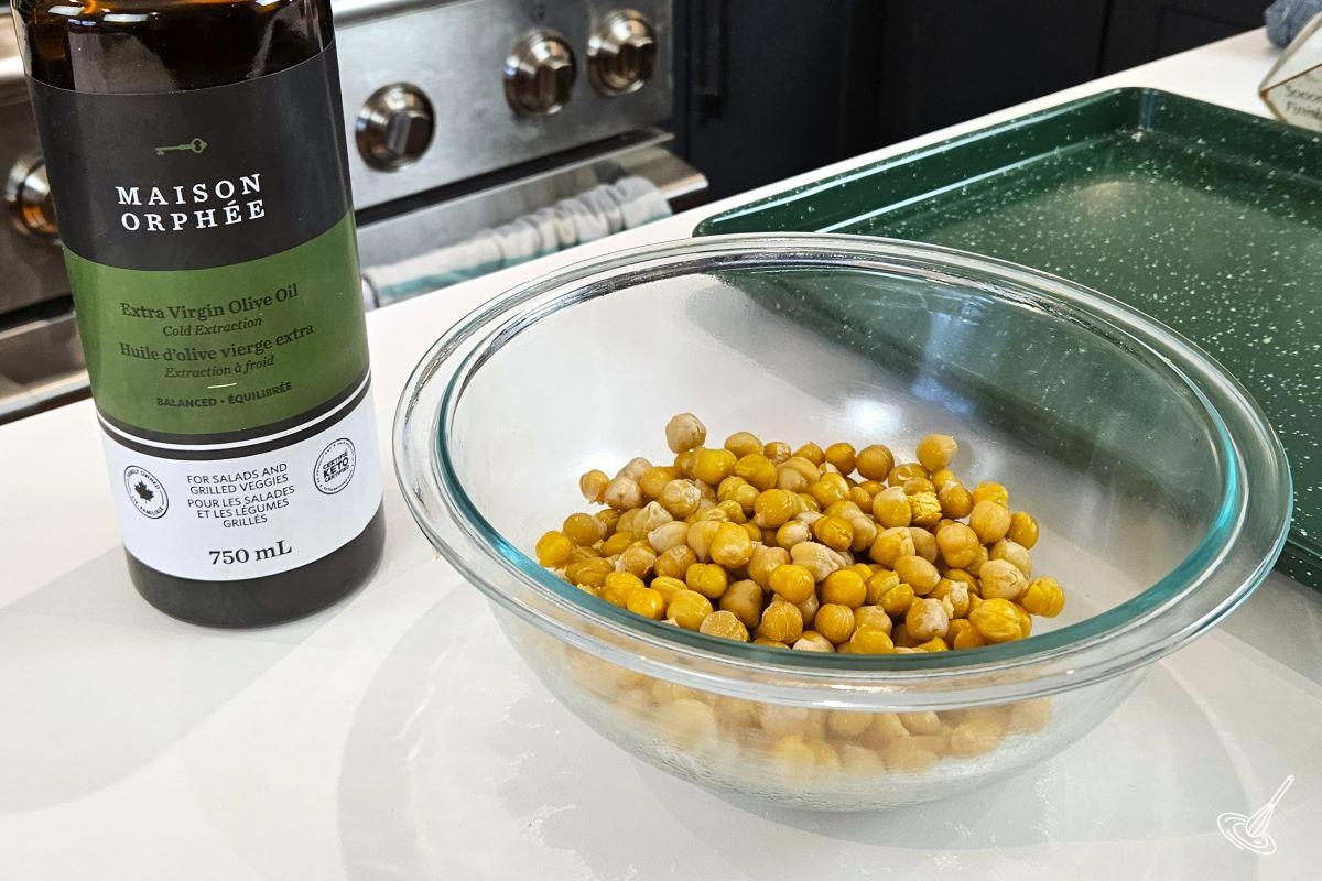 Peeled chickpeas in a small bowl with olive oil.