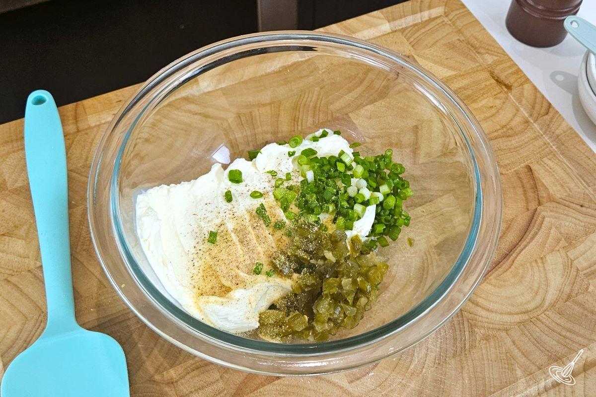 Cream cheese, green onions and jalapeño pieces, in a large bowl.