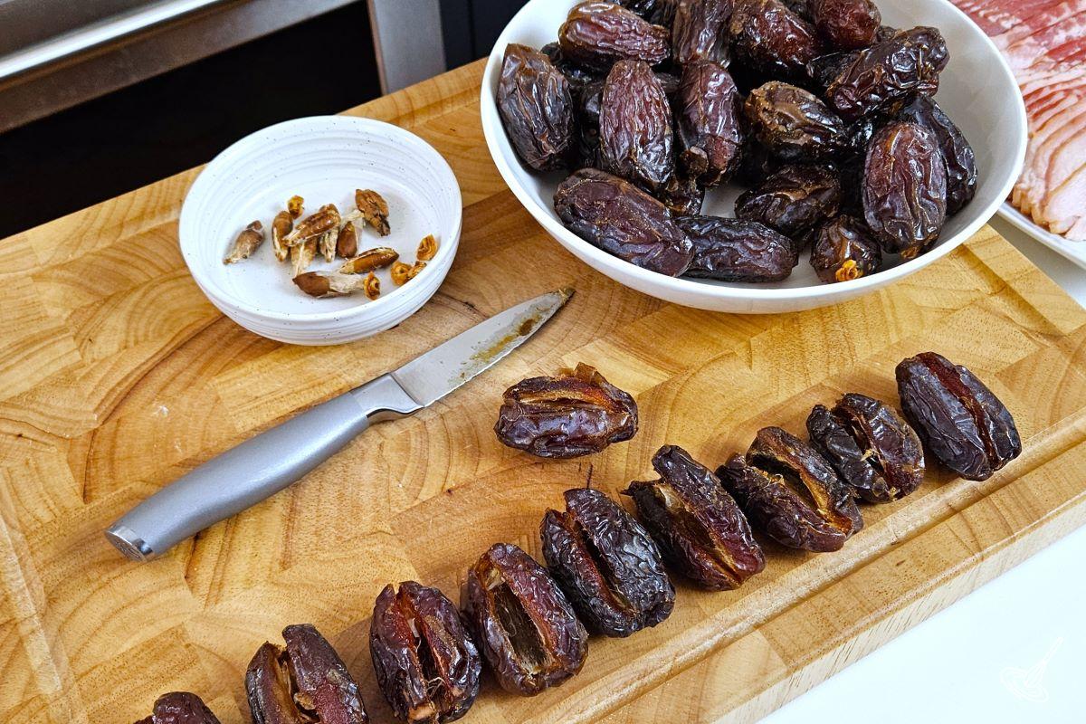 Medjool dates being cut open with the pits removed.