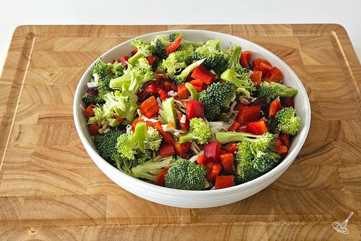 A bowl filled with chopped broccoli and red bell peppers. 