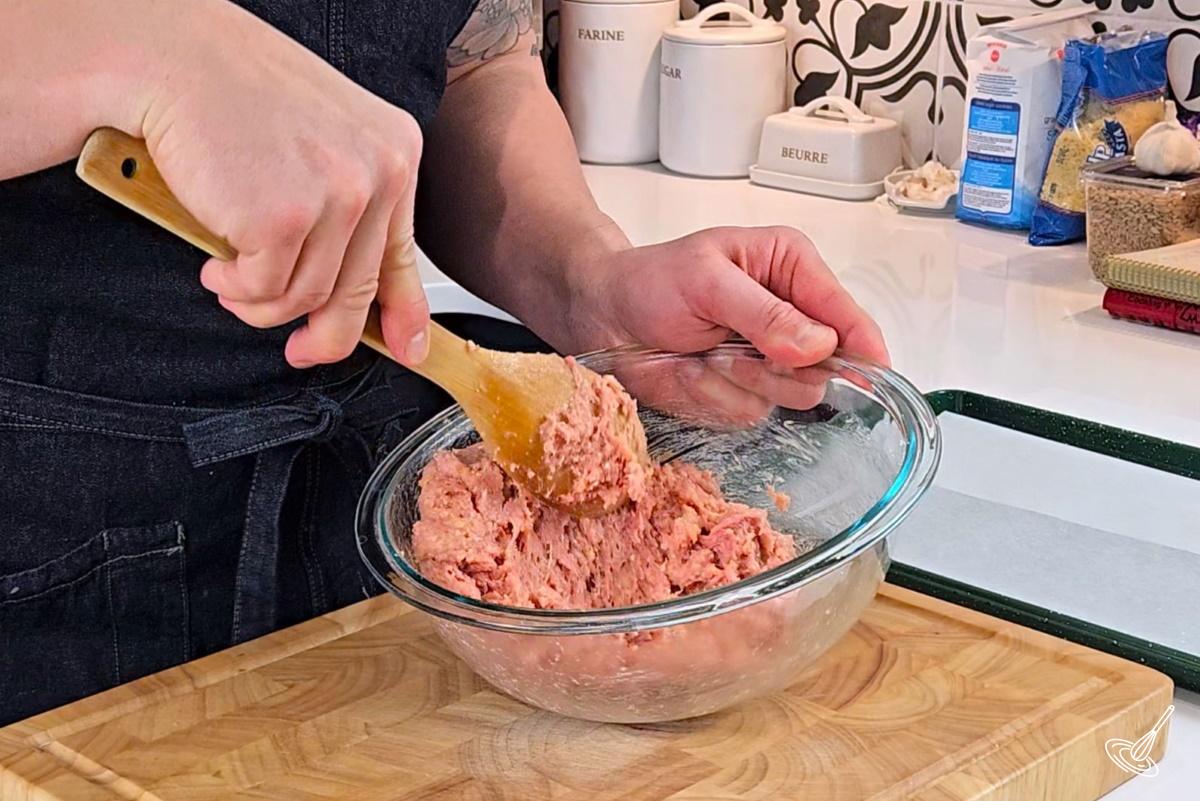 Someone mixing turkey meatball mixture in a large bowl. 