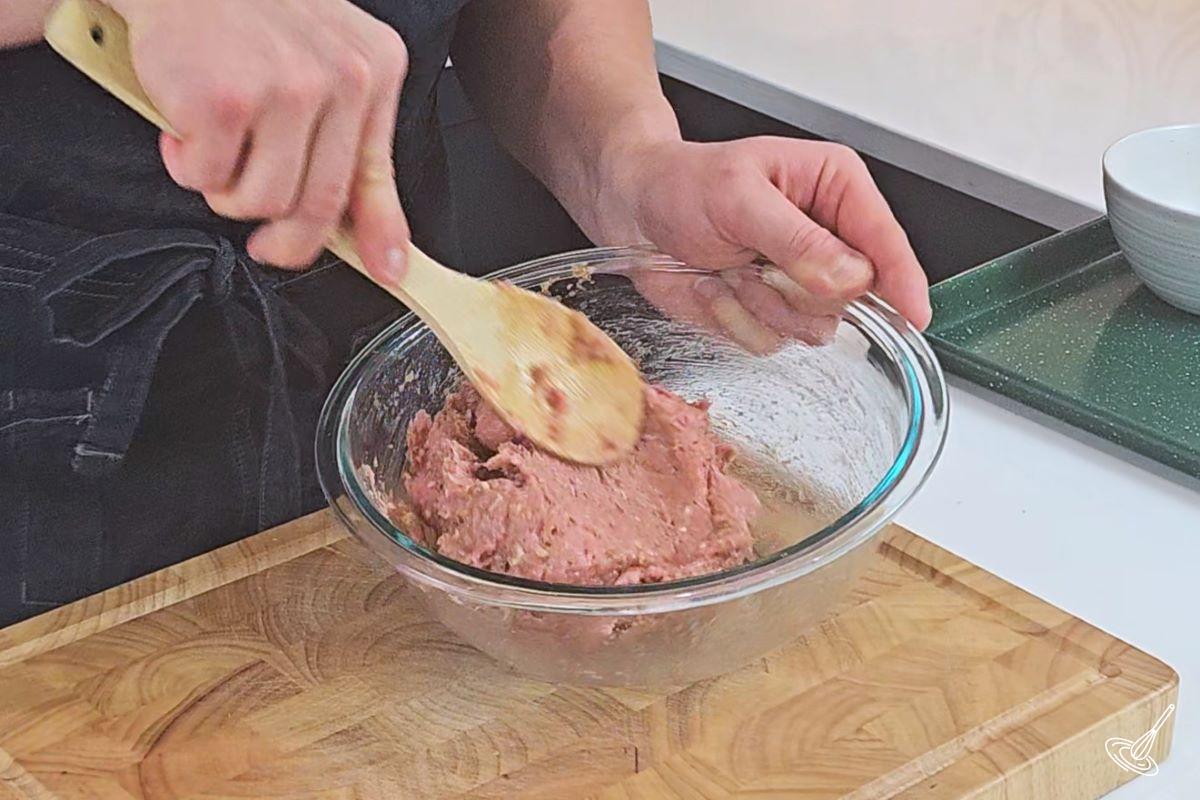 Someone mixing a turkey meatball mixture in a large bowl. 