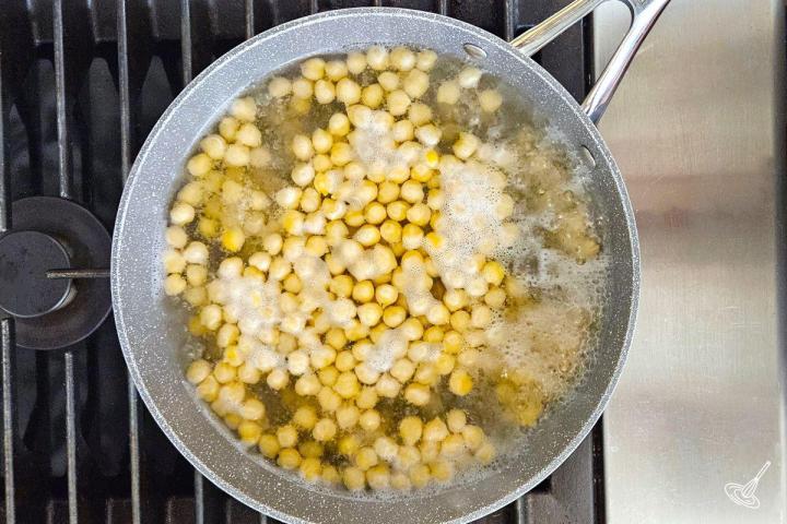 Chickpeas being boiled in a large pot.