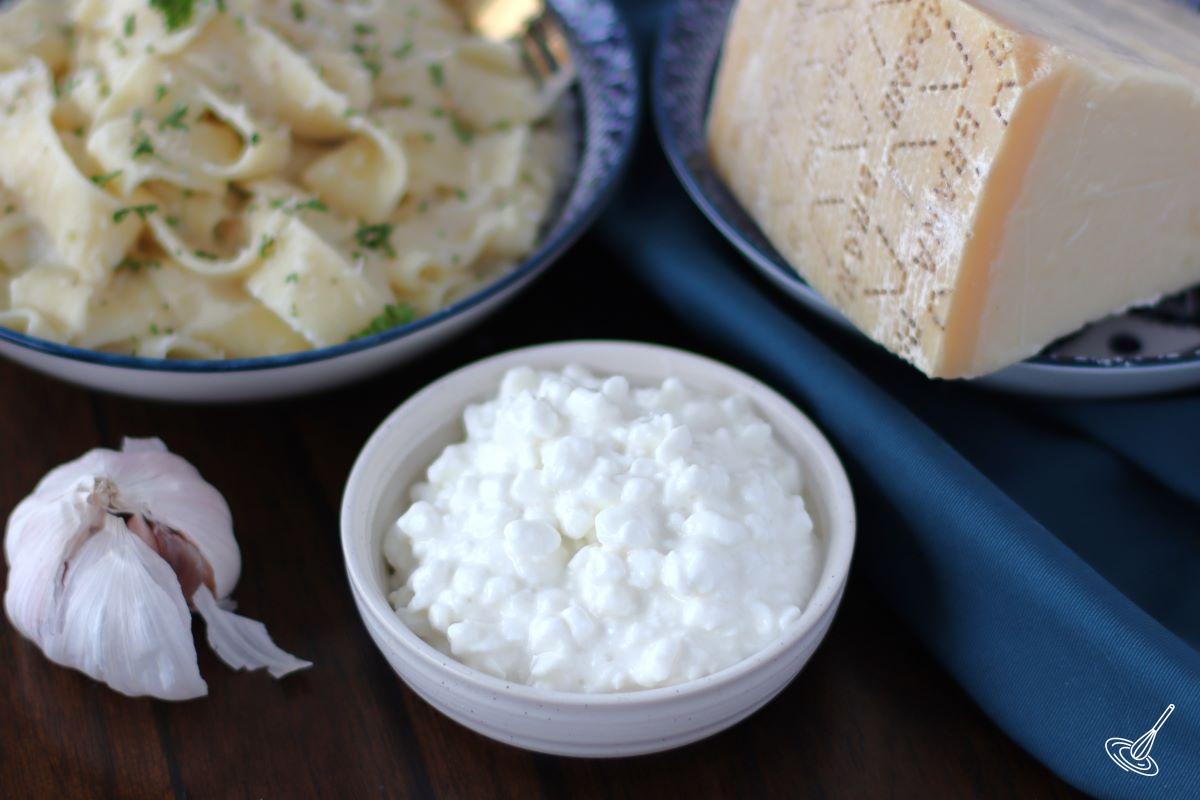 A dish of cottage cheese on the table with a bowl of Cottage Cheese Alfredo pasta. 