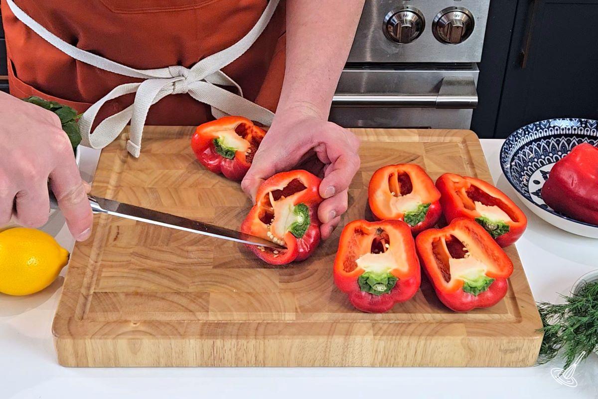 Someone cleaning out the insides of bell peppers.