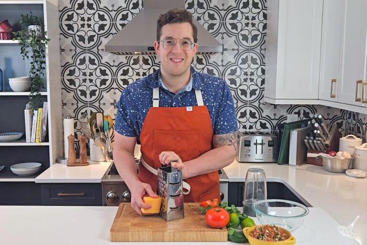 Someone grating cheddar cheese.