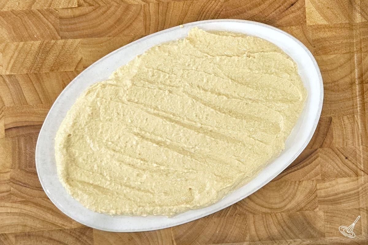 Creamy hummus spread on a serving plate.