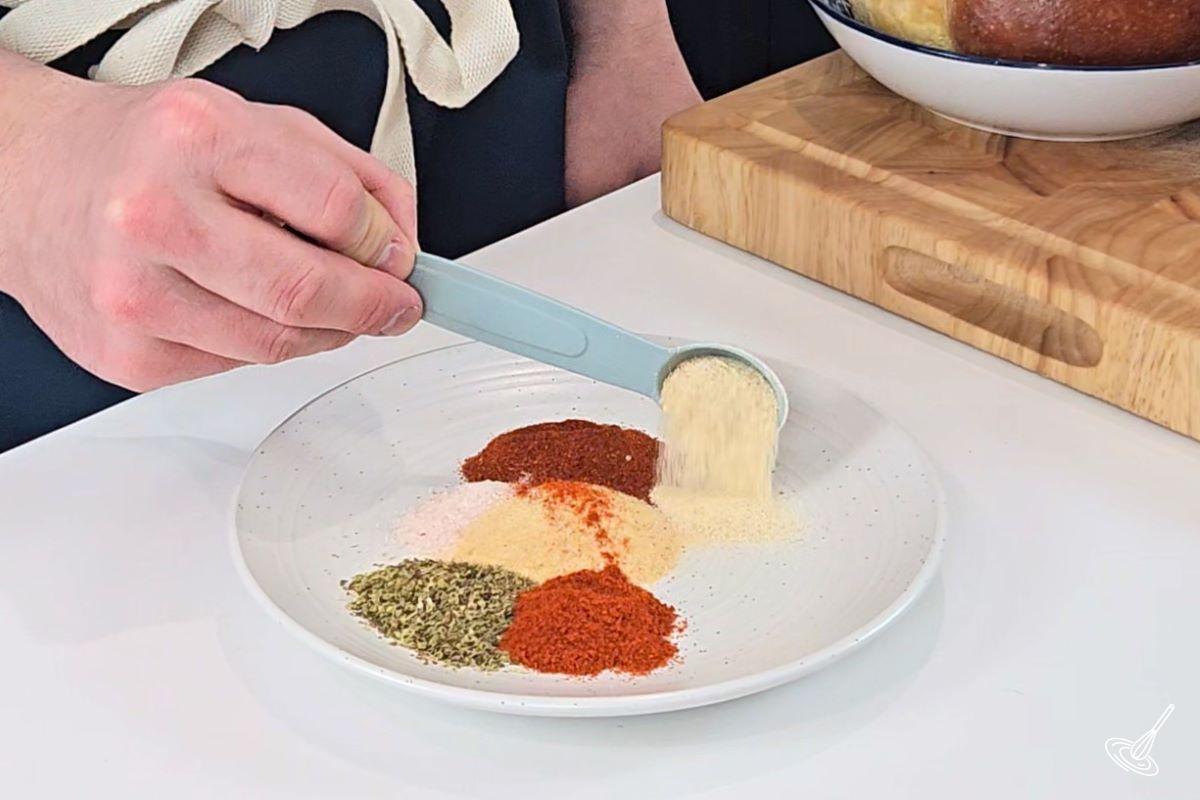 Someone making a Cajun spice blend on a plate. 