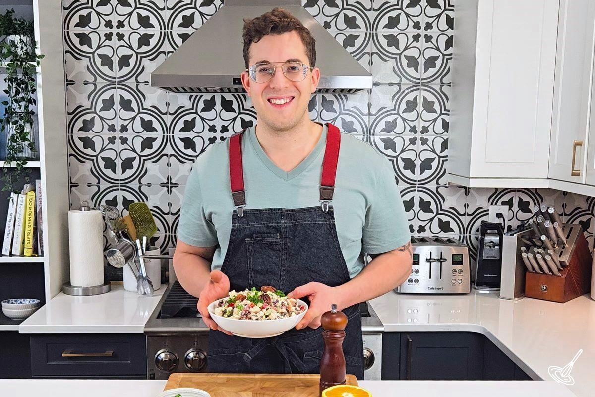 Welcome to French Kiss Cook. This is an image of a man smiling and holding a bowl of salad.
