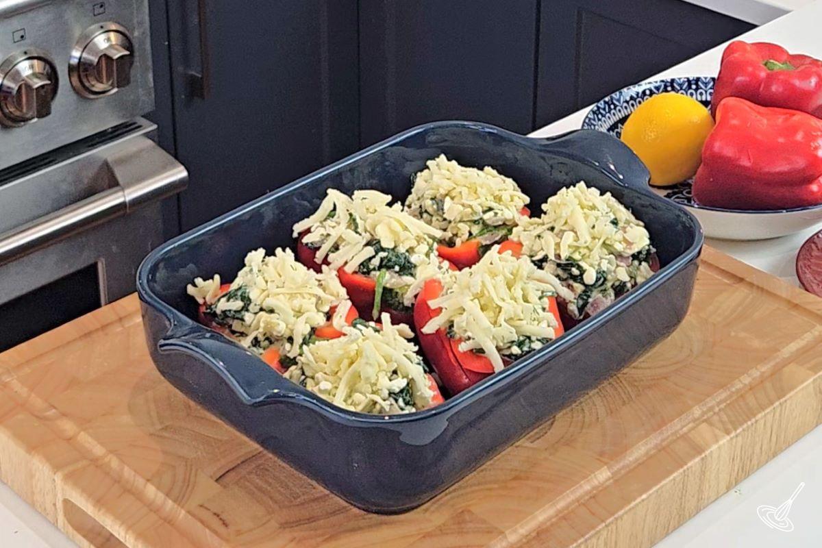 Six Spanakopita Stuffed Peppers in a baking dish.