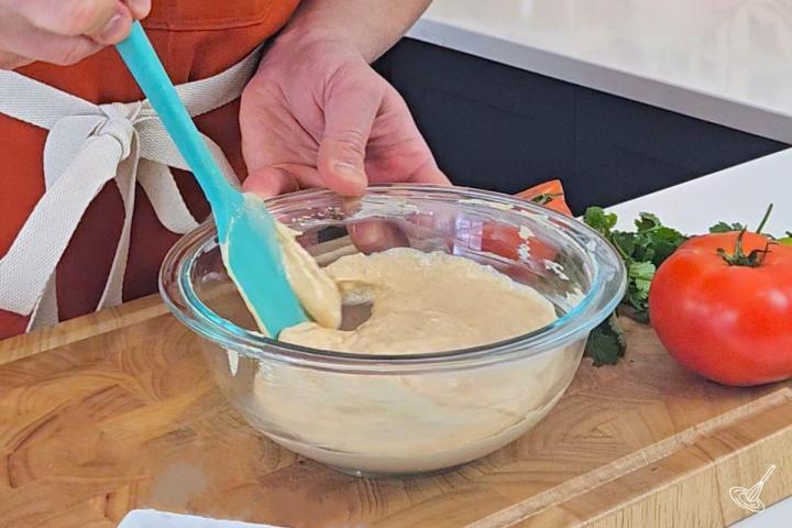 Someone stirring Cottage Cheese Queso in a bowl.