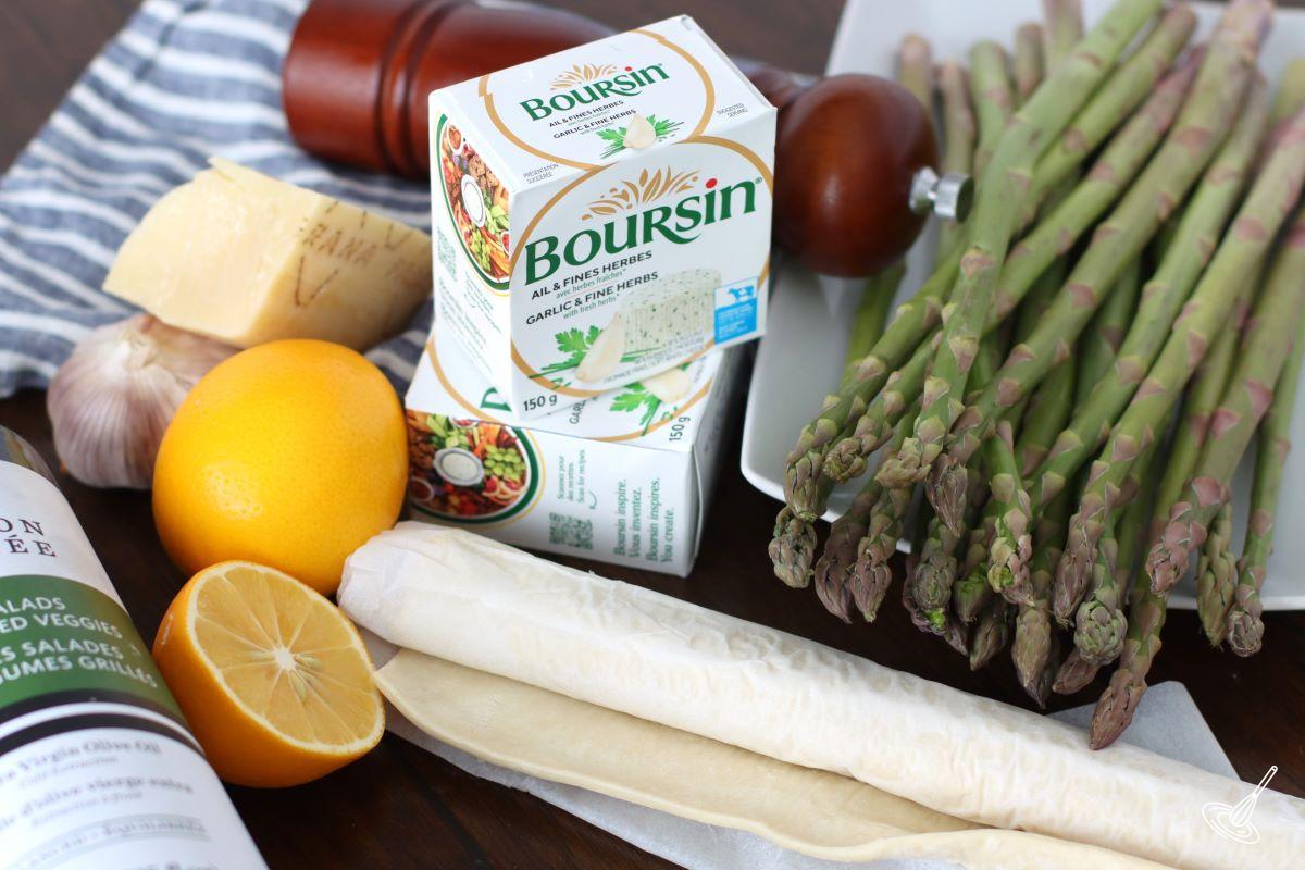 Ingredients laid out on the table, including; fresh asparagus, puff pastry, lemons, and parmesan.