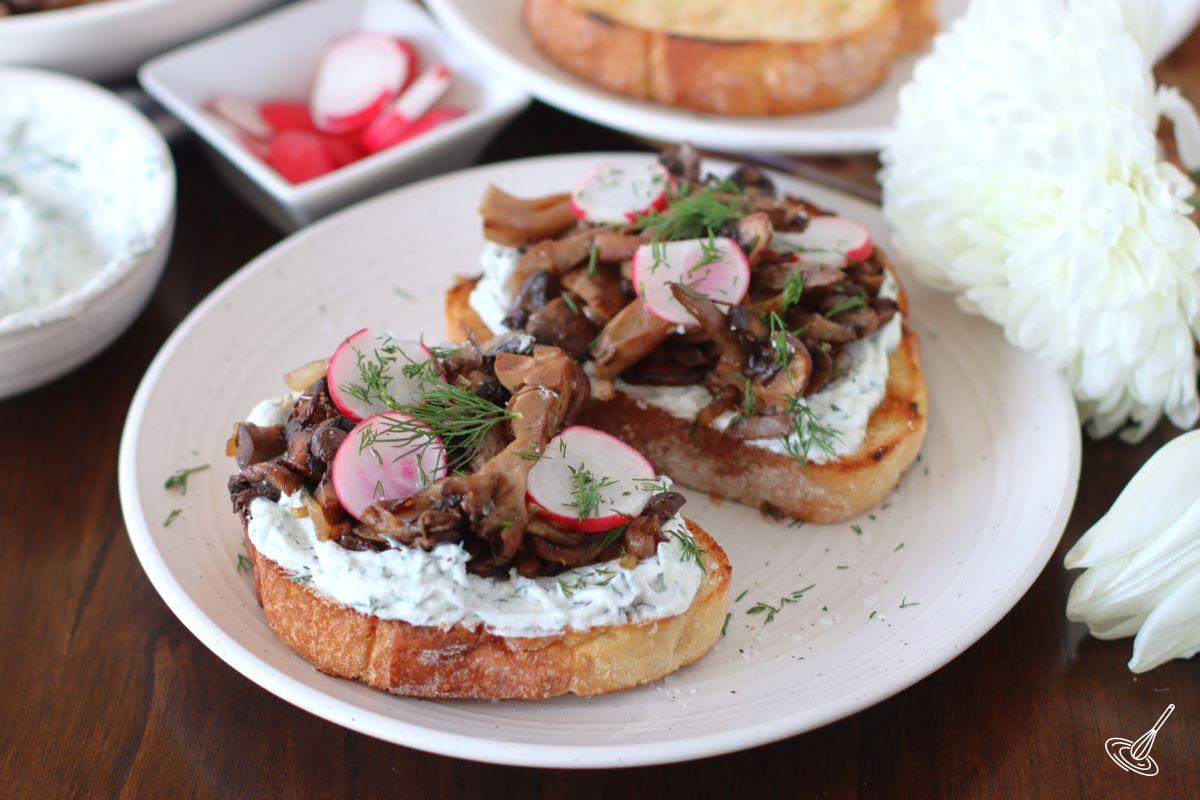 A couple of Mushroom Tartine on a white plate.