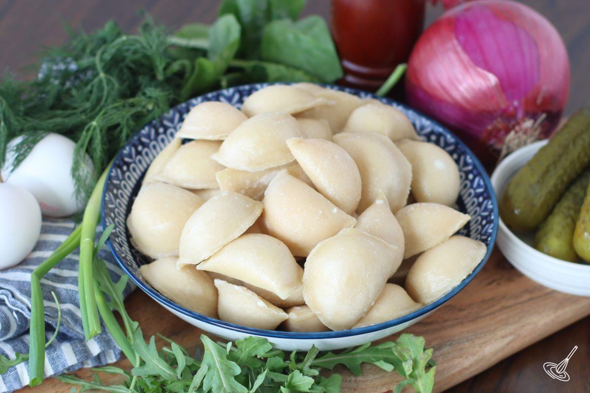 A large bowl of uncooked pierogies.