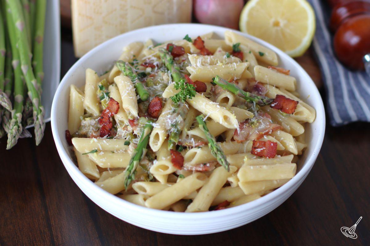 Creamy pasta with asparagus and bacon in a bowl. 