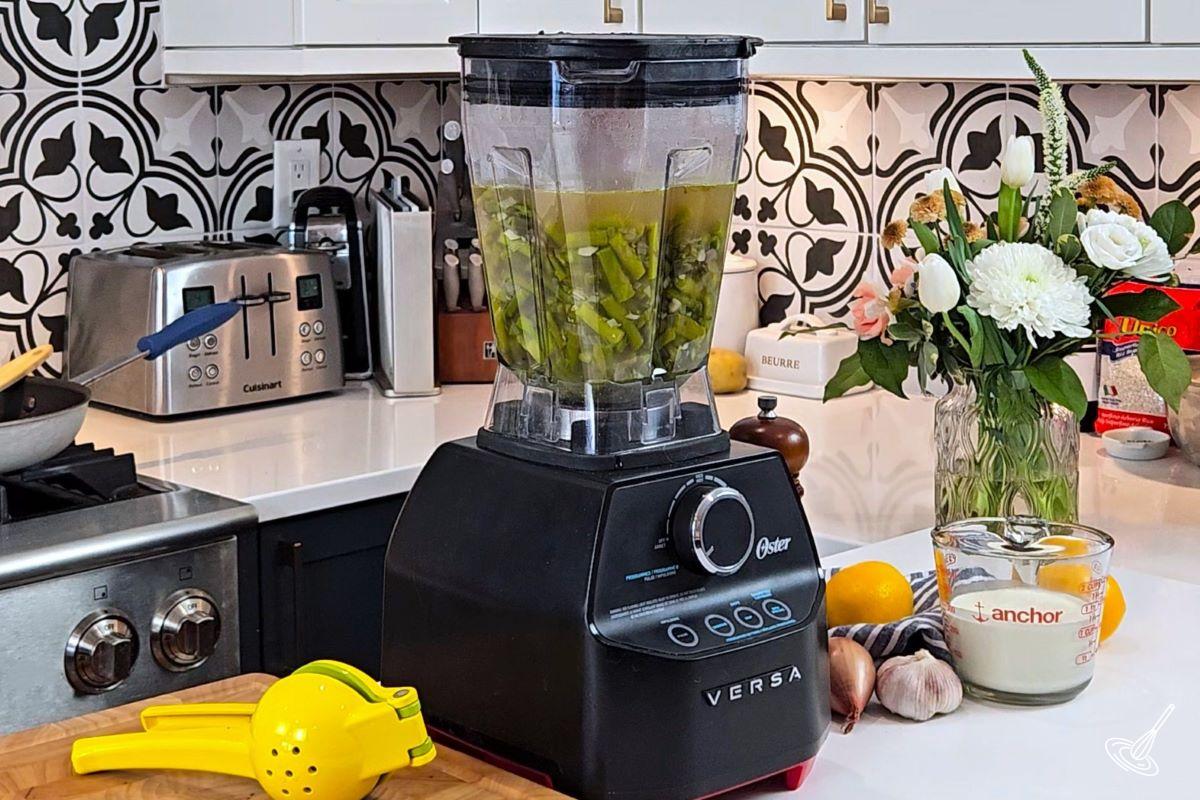 A large blender containing cooked vegetables and broth.