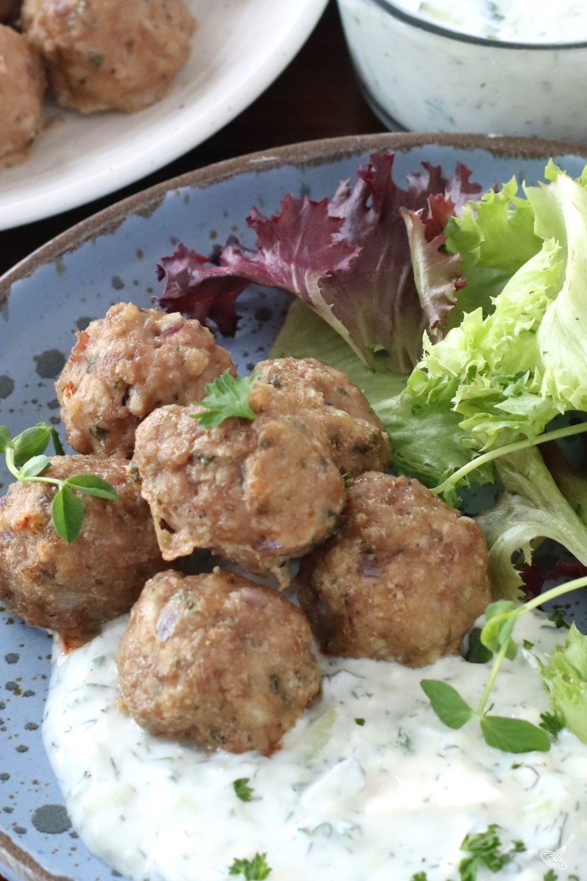 Greek Lamb Meatballs on a plate with tzatziki sauce. 