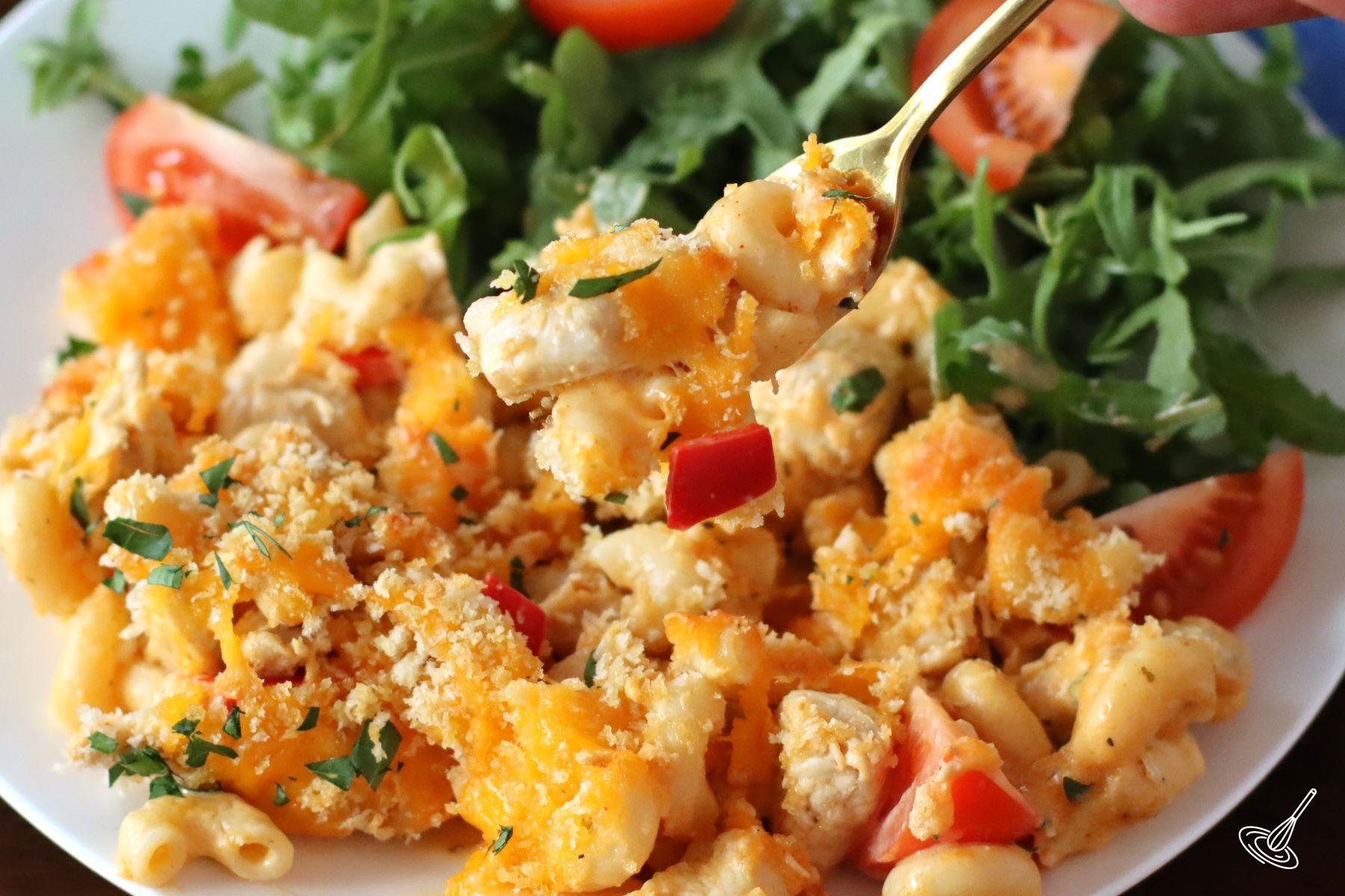 Someone taking a forkful of Cajun Chicken Mac and Cheese from a plate.