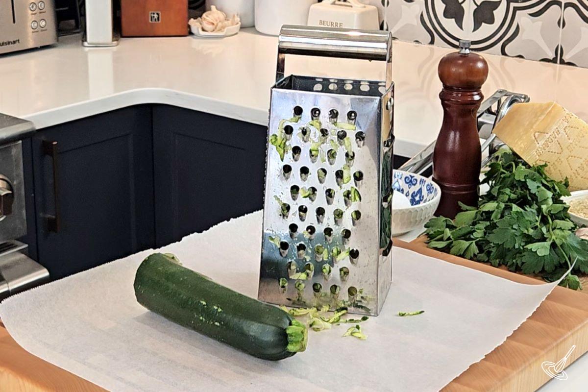 Someone grating a zucchini. 