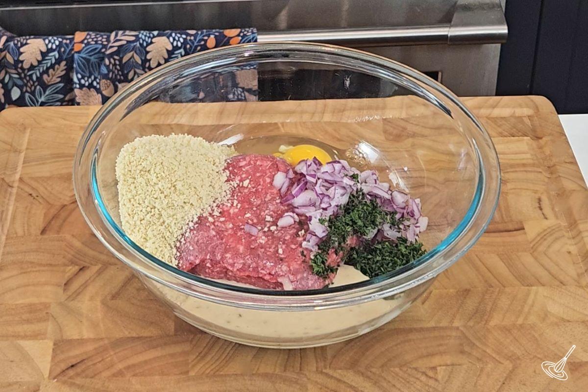 Meat mixture for meatballs in a large bowl. 