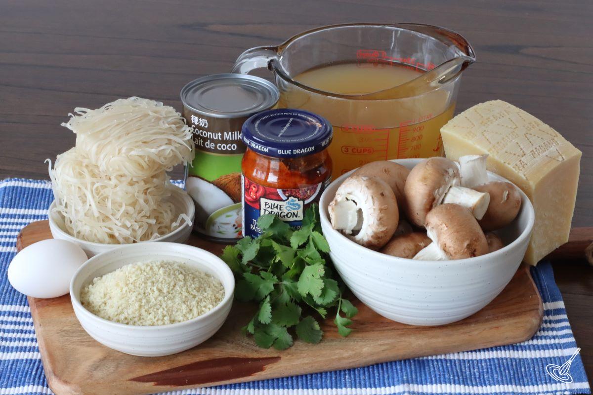 Ingredients on a cutting board including; mushrooms, cilantro, panko crumbs, chicken broth, and coconut milk.