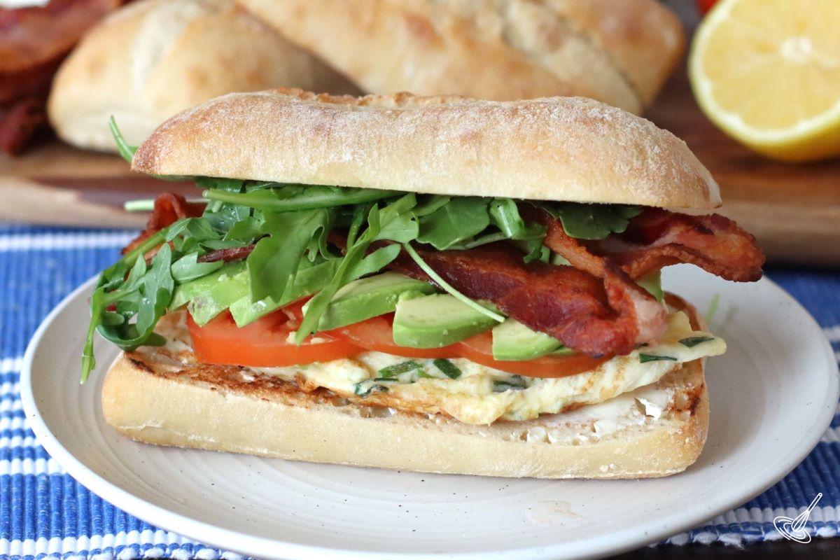 A ciabatta breakfast sandwich on a plate.