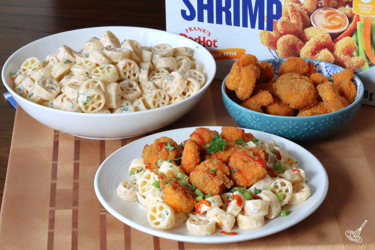 Pasta salad with a side dish of popcorn shrimp. 