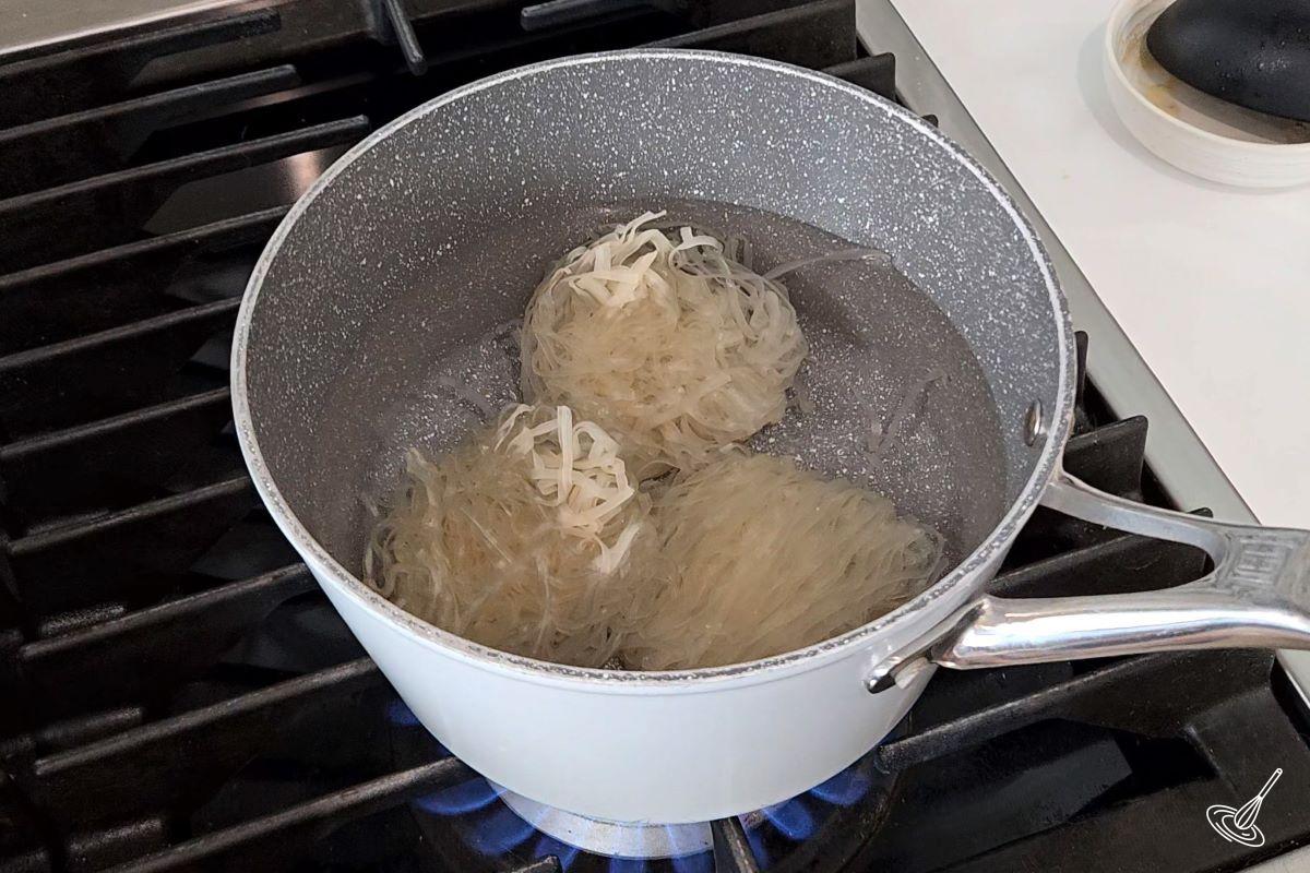 Rice noodles cooking in boiling water. 