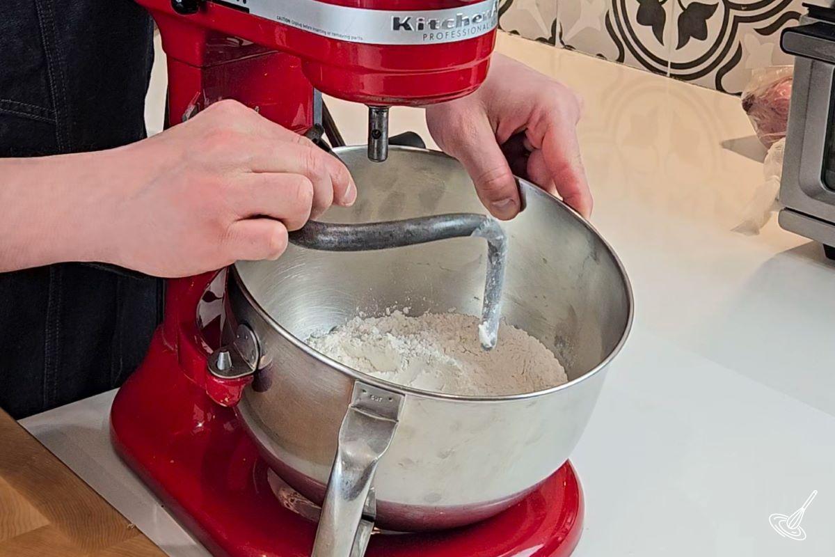 Someone attaching a dough hook to a mixing bowl. 