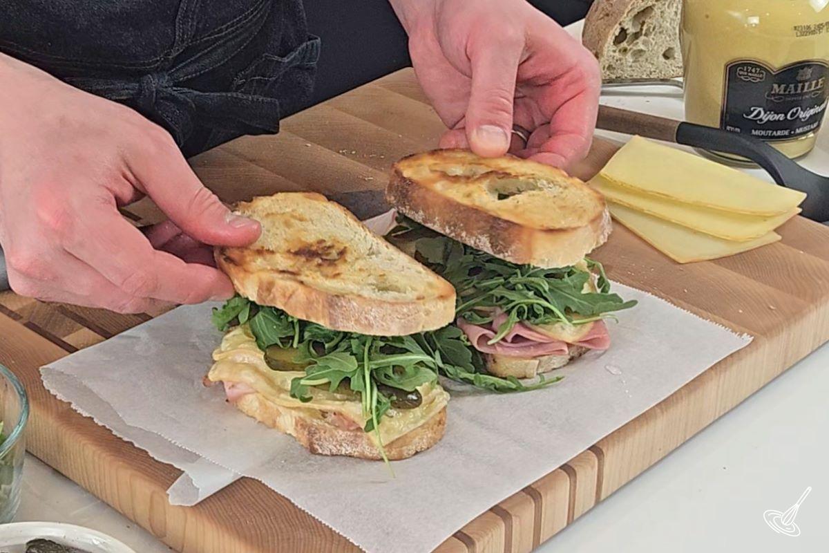 Someone placing grilled slices of bread on top of sandwiches.