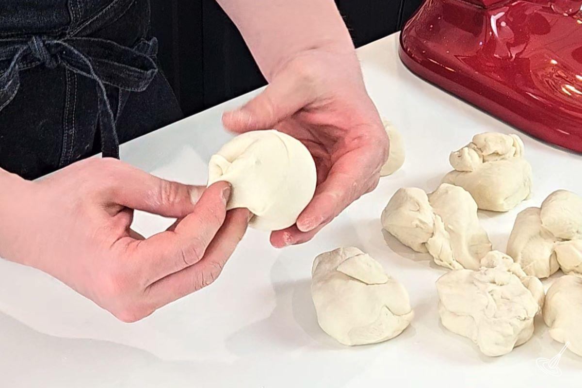 Someone shaping a dough into a ball.