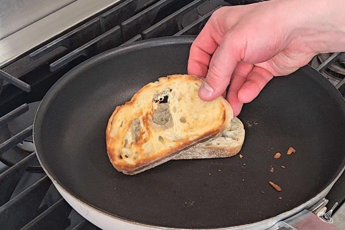 Someone grilling slices of bread in a frying pan. 